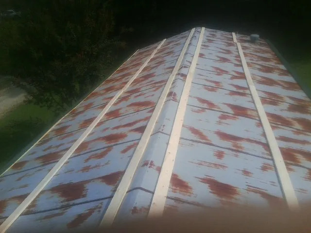 Rusted metal roof panels with new wood purlins before replacement — Storm Damage Roof Repair in Newfield by Roofing Brothers